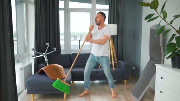 Caucasian Man Fooling While Cleaning House Singing Mop Instead Microphone — ストック動画