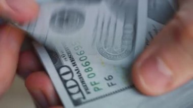Erkek eller Amerikan dolarlarını sayıyor ya da nakit ödüyor. Yatırım, başarı, finansal beklentiler veya kariyer gelişimi kavramı. Aşırı yakın çekim