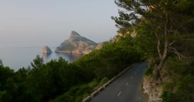 Scenic aerial view of a mountainous region in Majorca with cliffs. Panoramic view of a sunset over Mirador Es Colomer in Sierra de Tramuntana and blue sea, Balearic Islands, Spain.