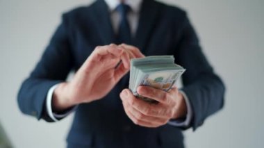 Formally dressed man makes money rain from US dollar bills. Slow motion. Concept of investment, success, financial prospects or career advancement