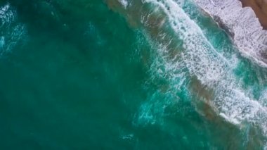 Deniz dalgaları kumlu sahil şeridinde dalgalanırken hiç bitmeyen güzel ve kusursuz görüntülerin drone görüntüsü. Akdeniz kıyısının en üst manzarası, dalgalar ıssız kumsala ulaşıyor. Güzel