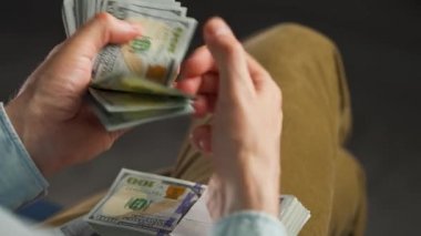 Erkek eller Amerikan dolarlarını sayıyor ya da nakit ödüyor. Yatırım, başarı, finansal beklentiler veya kariyer gelişimi kavramı. Aşırı yakın çekim