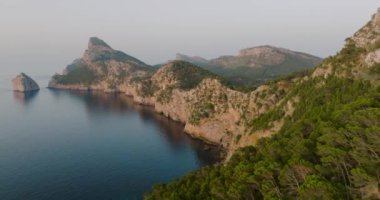 Scenic aerial view of a mountainous region in Majorca with cliffs. Panoramic view of a sunset over Mirador Es Colomer in Sierra de Tramuntana and blue sea, Balearic Islands, Spain.
