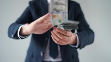 Formally dressed man makes money rain from US dollar bills. Concept of investment, success, financial prospects or career advancement