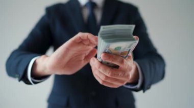 Formally dressed man makes money rain from US dollar bills. Slow motion. Concept of investment, success, financial prospects or career advancement