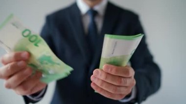Resmi olarak giyinmiş bir adam Euro banknotlarını sayıyor, yakın plan. Yatırım, başarı, finansal beklentiler veya kariyer ilerlemesi kavramı.