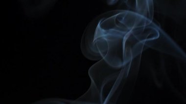 Soyut duman siyah arka planda güzel girdaplarda yükselir. Yavaş çekim. 