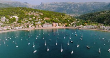 Majorca, Spain. Aerial view of summer resort town Port de Soller on Mallorca Majorca island, sandy beach, boats, yachts, clear waters of Mediterranean Sea - landscape of Balearic Islands from above