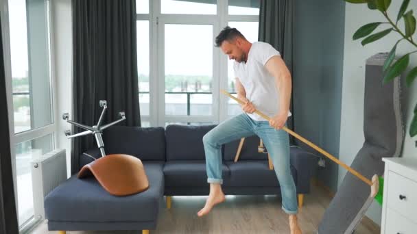 Homem Limpando Casa Divertindo Dançando Com Uma Vassoura Movimento Lento — Vídeo de Stock