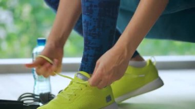 Ayakkabı bağcığını bağlayan kadın antrenmana ya da koşuya gidiyor, kapat..