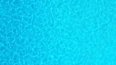 Yüzme havuzundaki saf mavi suyun yüzeyinde ışık yansımaları var. Hava görüntüleri