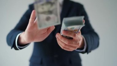 Formally dressed man makes money rain from US dollar bills. Slow motion. Concept of investment, success, financial prospects or career advancement