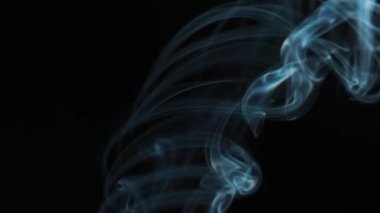 Soyut duman siyah arka planda güzel girdaplarda yükselir. Yavaş çekim. 