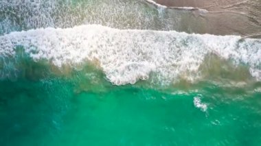 Deniz dalgaları kumlu sahil şeridinde dalgalanırken hiç bitmeyen güzel ve kusursuz görüntülerin drone görüntüsü. Akdeniz kıyısının en üst manzarası, dalgalar ıssız kumsala ulaşıyor. Güzel