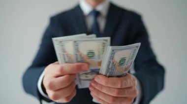 Formally dressed man counting US Dollar bills, close-up. Concept of investment, success, financial prospects or career advancement. Slow motion