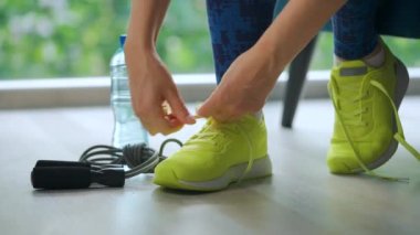 Ayakkabı bağcığını bağlayan kadın antrenmana ya da koşuya gidiyor, kapat..