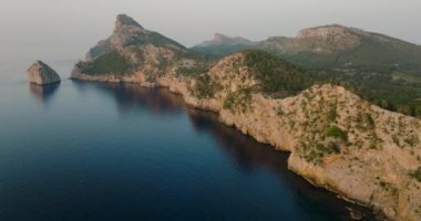 Scenic aerial view of a mountainous region in Majorca with cliffs. Panoramic view of Mirador Es Colomer in Sierra de Tramuntana and blue sea, Balearic Islands, Spain.