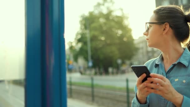 Woman Stands Public Transport Stop Using Smartphone Waiting Tram City — Vídeo de Stock