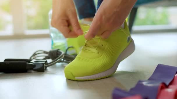 トレーニングやジョギングに行くスニーカーに靴ひもを結ぶ女性 閉じる — ストック動画