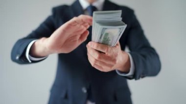 Formally dressed man makes money rain from US dollar bills. Slow motion. Concept of investment, success, financial prospects or career advancement