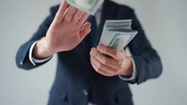 Formally dressed man makes money rain from US dollar bills. Concept of investment, success, financial prospects or career advancement