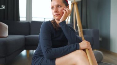 Kadın odanın ortasında derin düşüncelere dalmış oturuyor. Temizlenmesi gerekiyor, ama işi ağırdan alıyor. Yavaş çekim