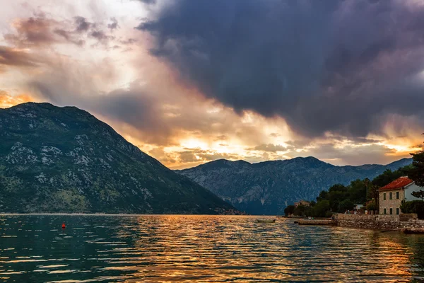 Sunset on the sea with the foggy mountains — Stock Photo, Image