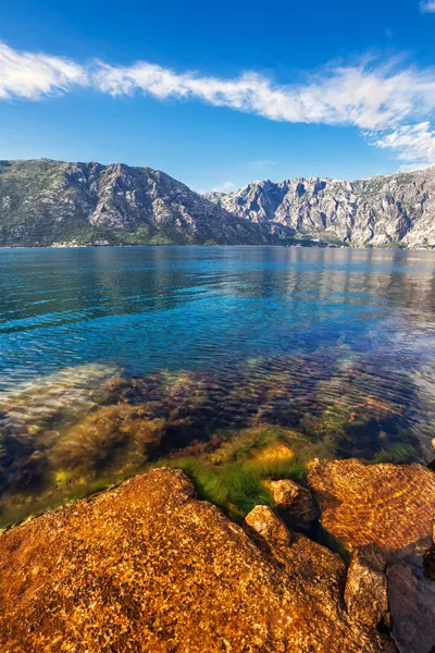 Stenarna stranden med havet och bergen — Stockfoto