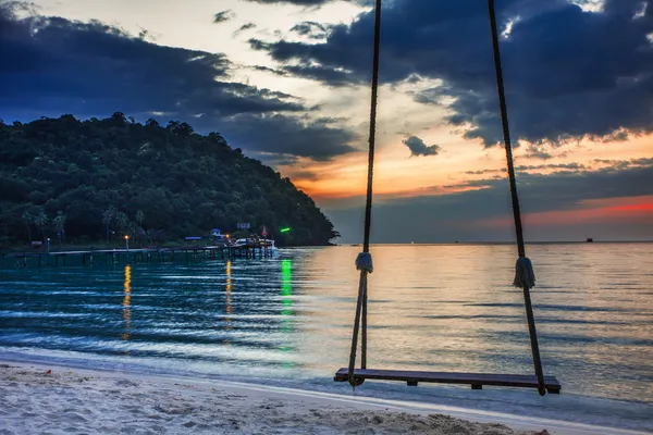 Swing op zonsondergang op het strand — Stockfoto