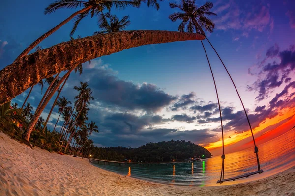 Swing op zonsondergang op het strand — Stockfoto