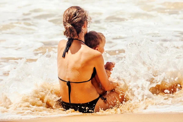 Μητέρα με παιδί που παίζει με τα κύματα της θάλασσας — Φωτογραφία Αρχείου