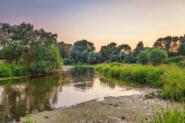 Yaz günbatımında alan ve nehir