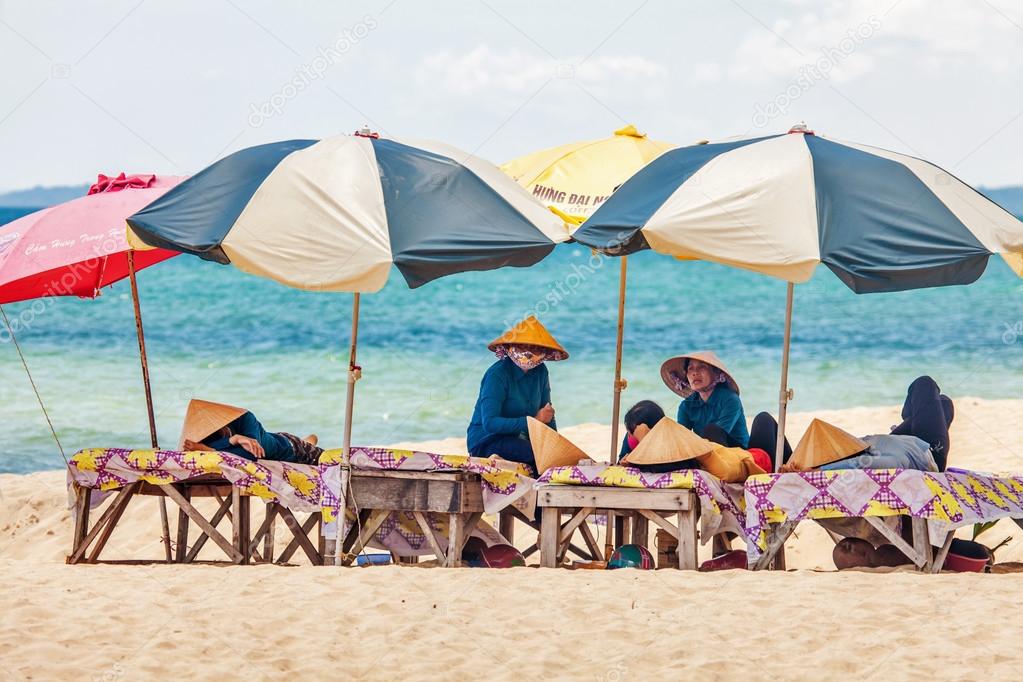  Beach masseuses resting  under umbrellas