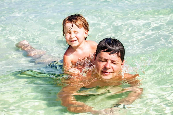 Pai e filho nadando no mar — Fotografia de Stock