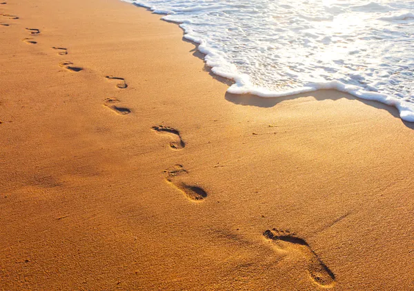 Strand, Welle und Schritte bei Sonnenuntergang — Stockfoto