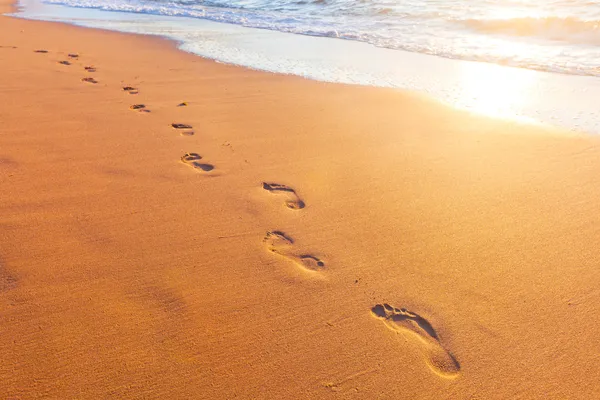 Beach, wave and footsteps at sunset time — Stock Photo, Image