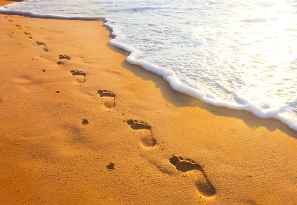 Footsteps of one-legged people at sunset time — Stock Photo, Image