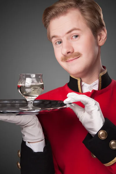 Garçom sorridente em uniforme vermelho — Fotografia de Stock