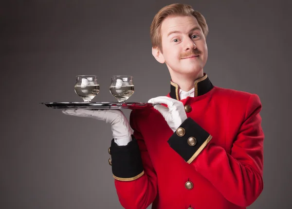 Garçom sorridente em uniforme vermelho — Fotografia de Stock