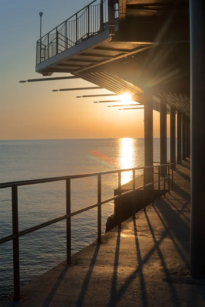 Ηλιοβασίλεμα τα pier κατά μήκος της ακτής Royalty Free Εικόνες Αρχείου