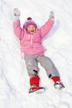 winter park tepelerde aşağı yuvarlanan mutlu çocuk