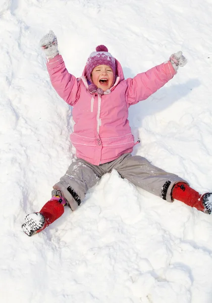 Gelukkig kind rollen beneden de heuvels in winter park — Stockfoto