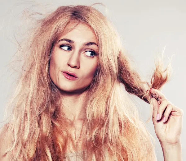 Young woman looking at split ends — Stock Photo, Image