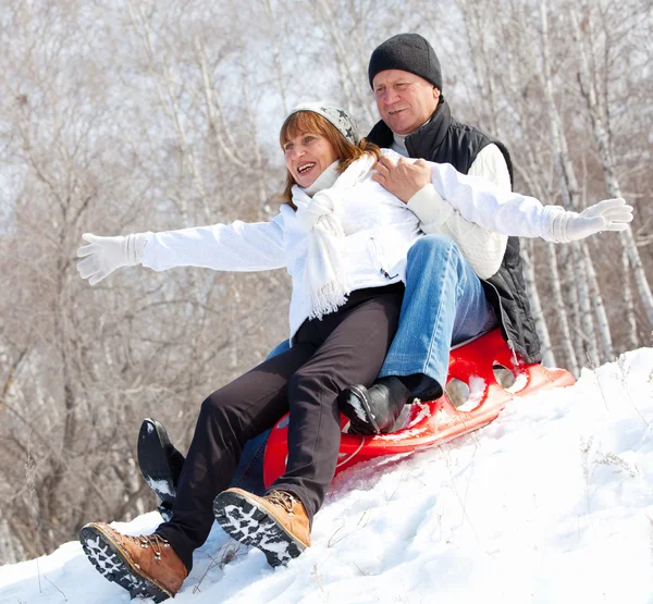 Mature couple sledding — Stock Photo, Image
