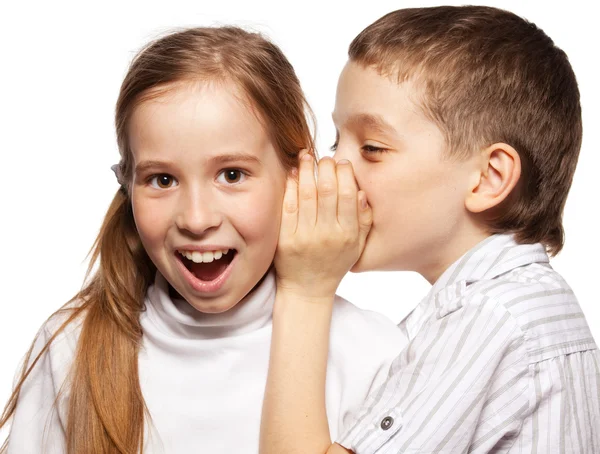 Мальчик шепчет девушке на ухо секрет — стоковое фото