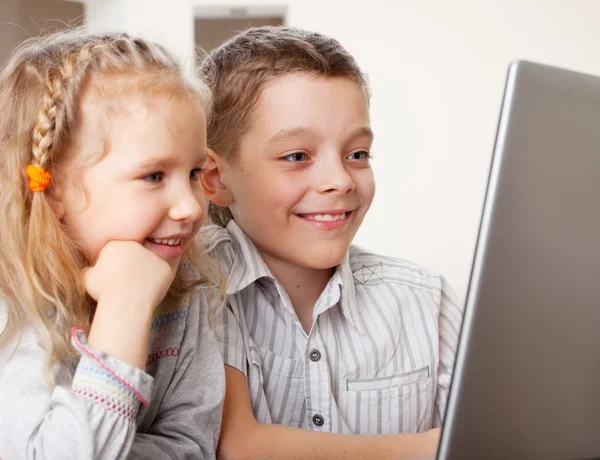 Crianças felizes jogando laptop em casa — Fotografia de Stock