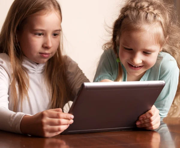 Tablet üzerinde oynayan çocuklar