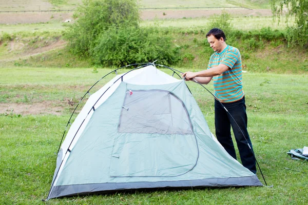 A man puts a tent — Stock Photo, Image