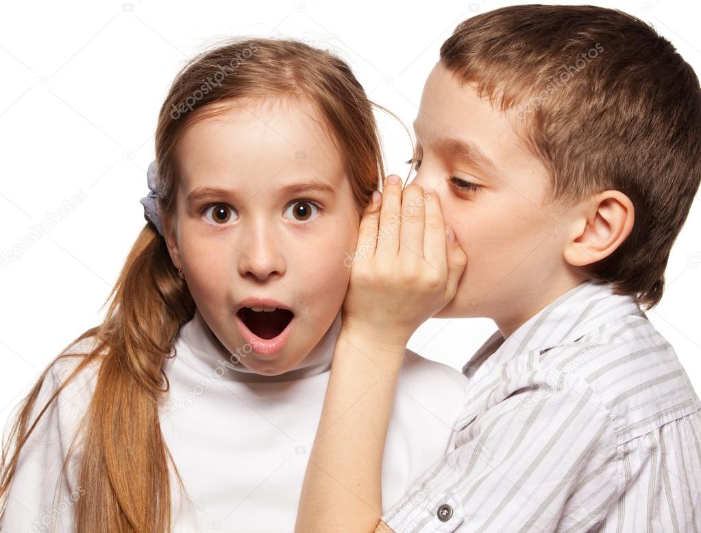 Boy whispers girl in the ear secret