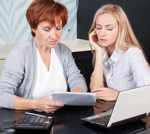 Två kvinnor diskuterar dokument hemma — Stockfoto